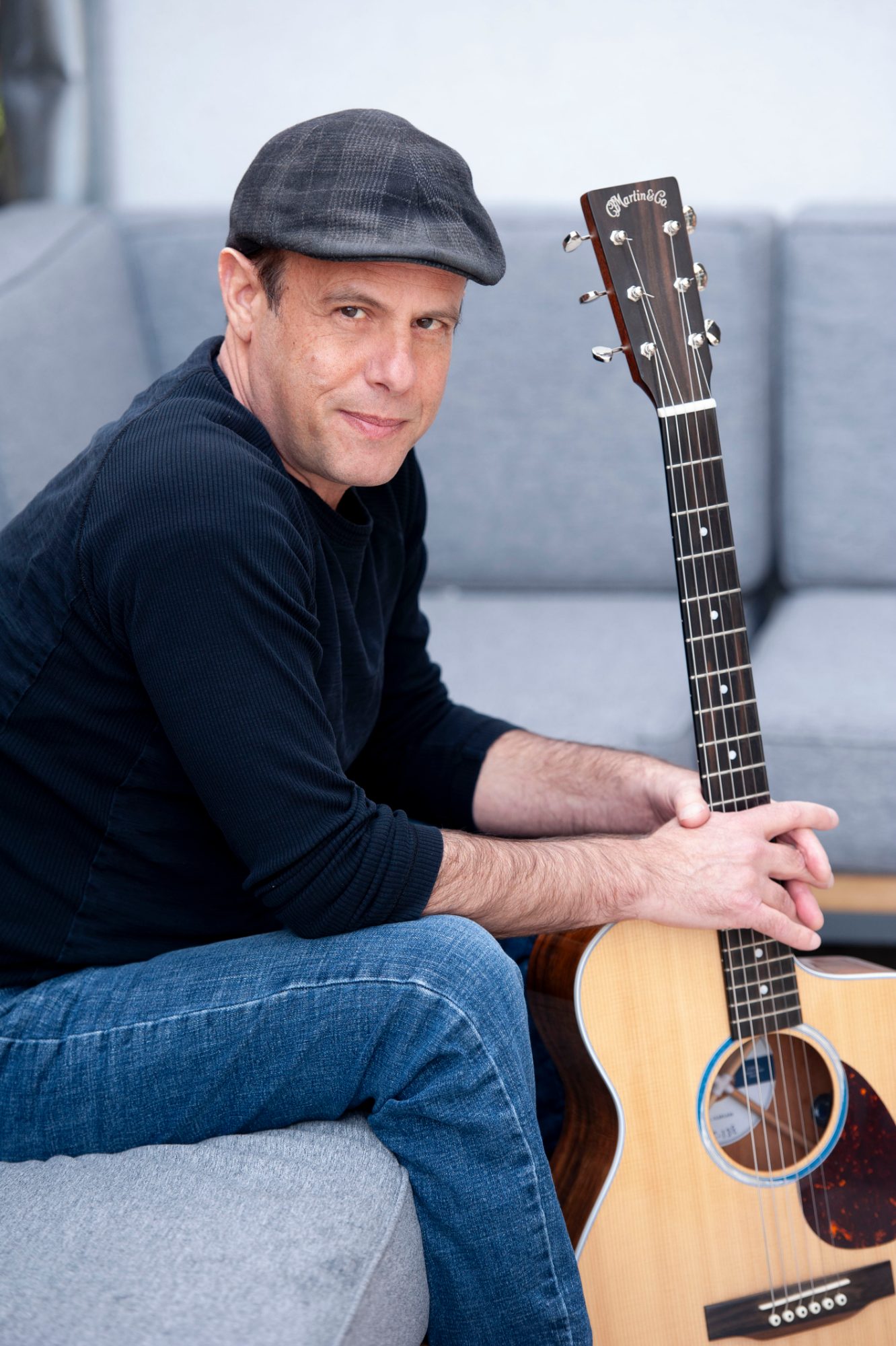 Peter Gross seated with Martin guitar