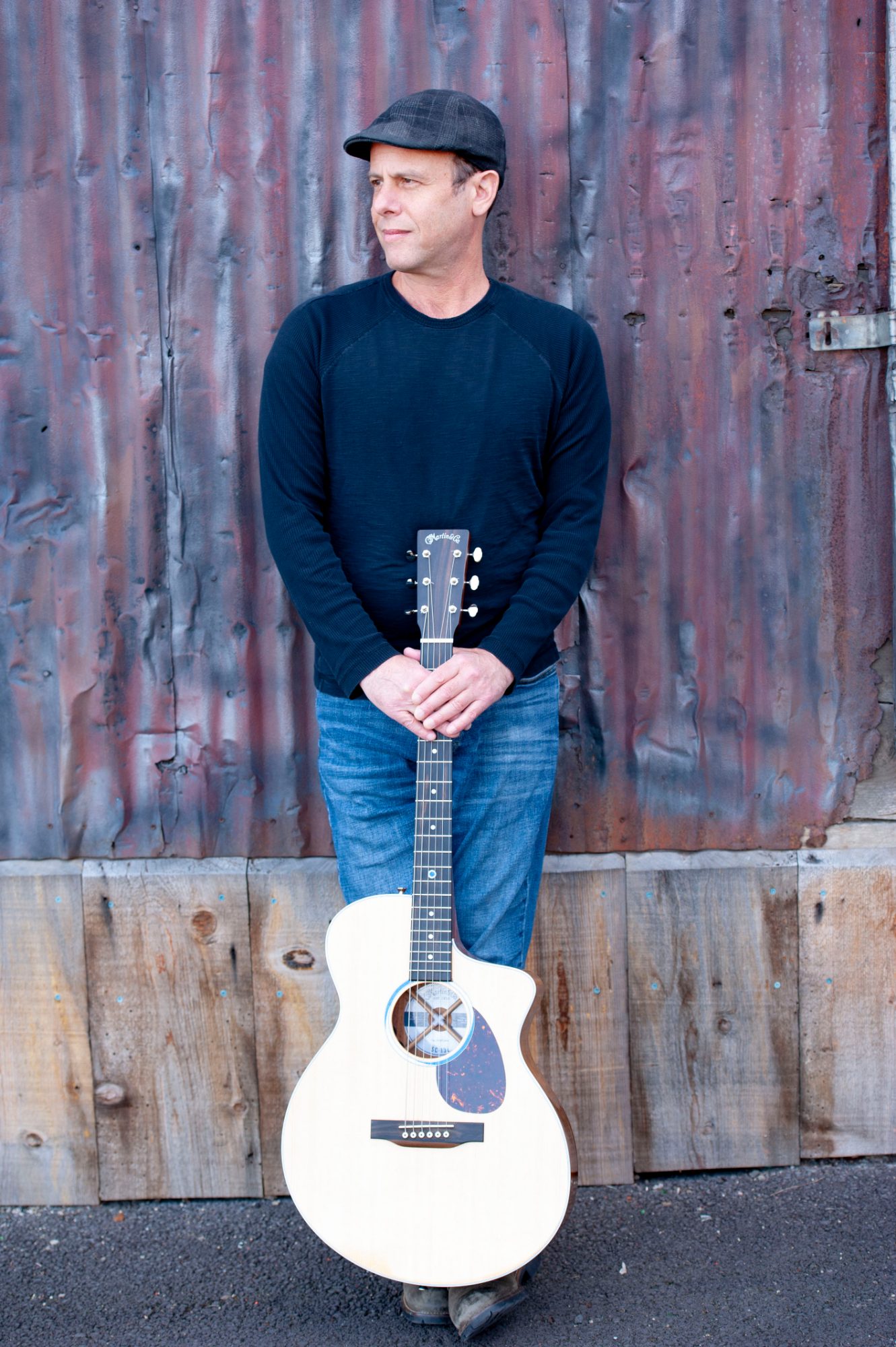 Peter Gross standing with white guitar